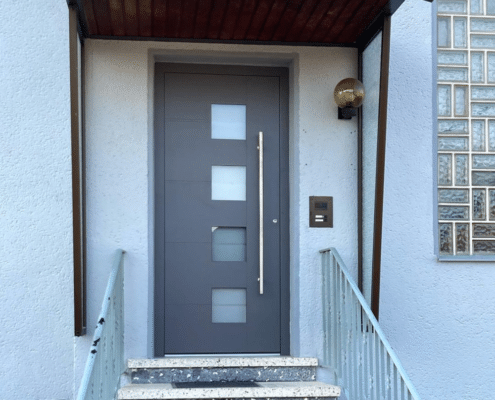 Graue Aluminium-Haustür mit vier Glasfeldern und Edelstahl-Stoßgriff
